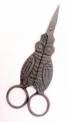 A pair of scissors with an owl-shaped etching on the handles, in a matte black color.
