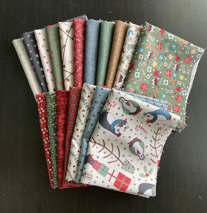 A collection of 18 different fabric pieces from the Three Wise Penguins fabric collection, displayed folded on a surface.